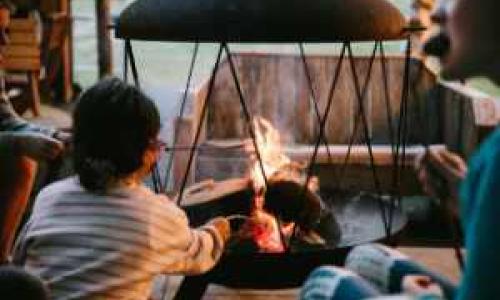 children roasting marshmallows at a fire pit